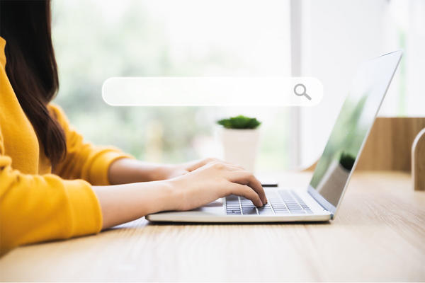 Woman using computer laptop on wood desk. 