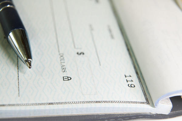 Pen laying on an open check book.
