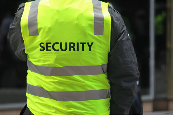 A security guard wearing a high vis vest