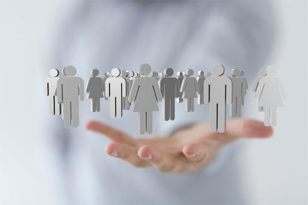 Hand holding cut outs of miniature people