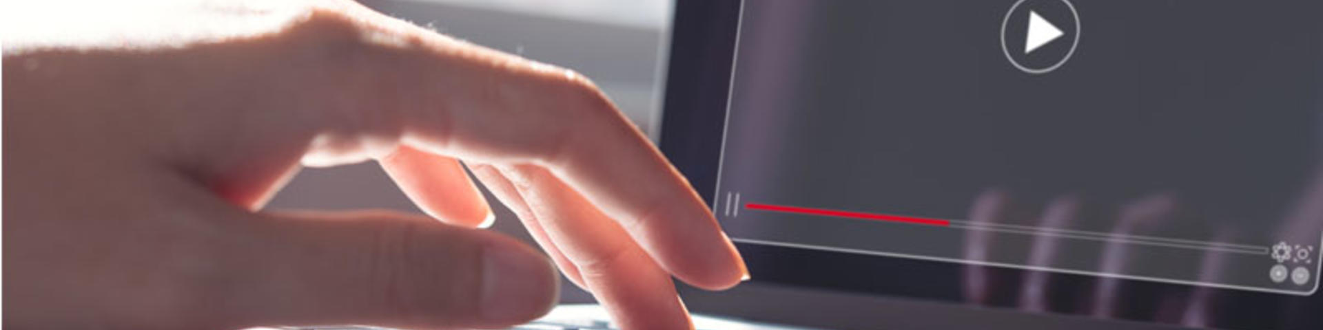 Woman working on laptop computer watching video player
