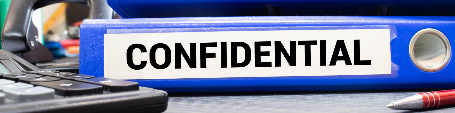 Inside of a filing cabinet with green folders and focus on confidential label