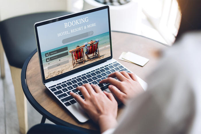 Portrait of woman use technology of laptop computer for hotel and resort booking online